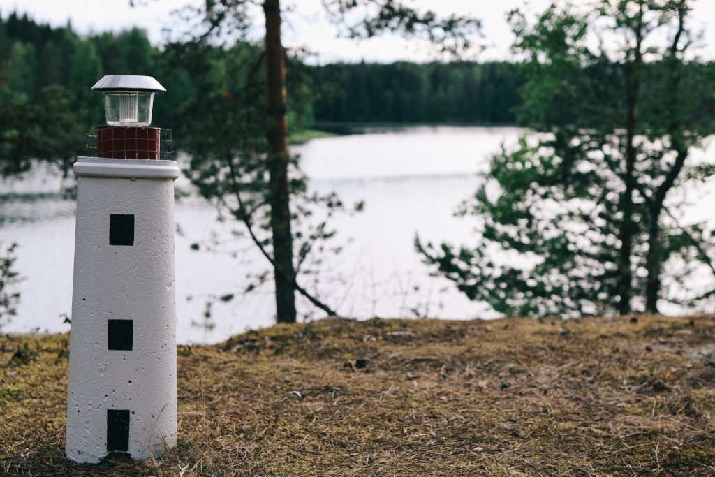 Our cottage via Mokkiavain Cottages. A small statue of a lighthouse overlooking a Finnish lake in Tampere.