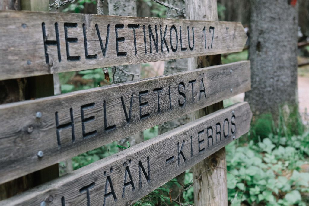 Helvetinjärvi National Park. A wooden sign showing the way to Helvetinjärvi National Park.