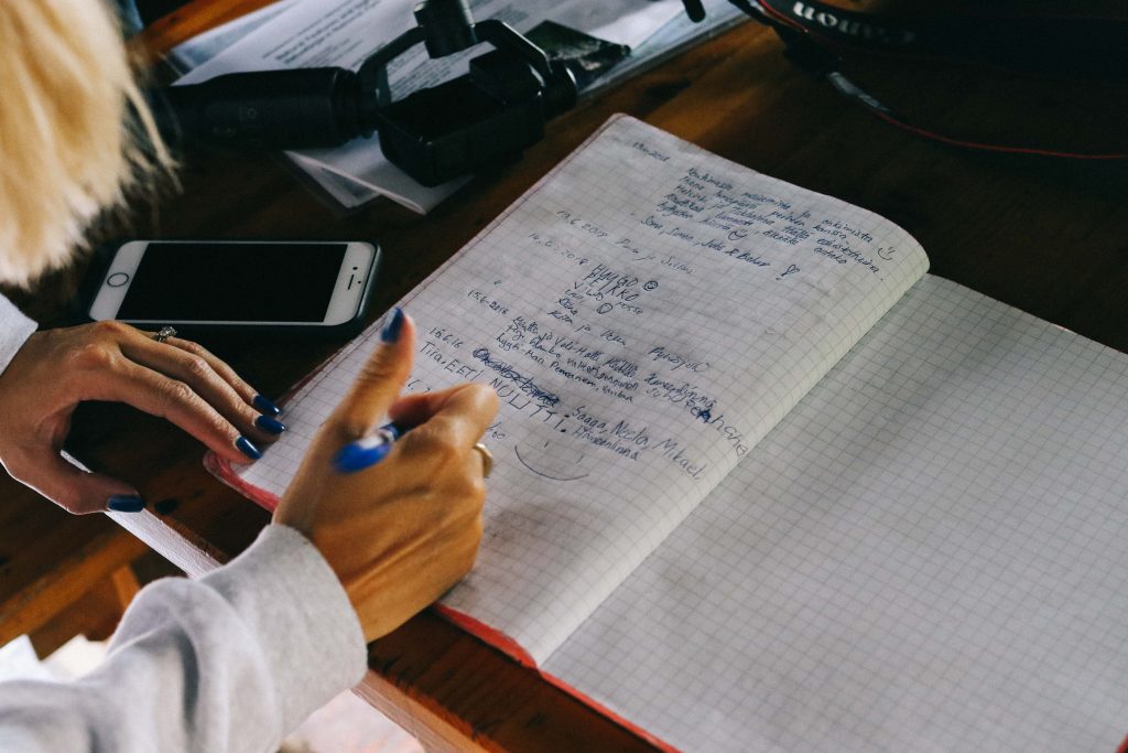 Helvetinjärvi National Park. A girl signing a guest book in a cabin in Helvetinjärvi National Park.