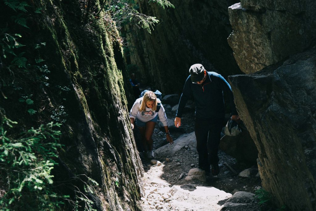 Helvetinjärvi National Park. A girl climbing a steep rocky path in Helvetinjärvi National Park.